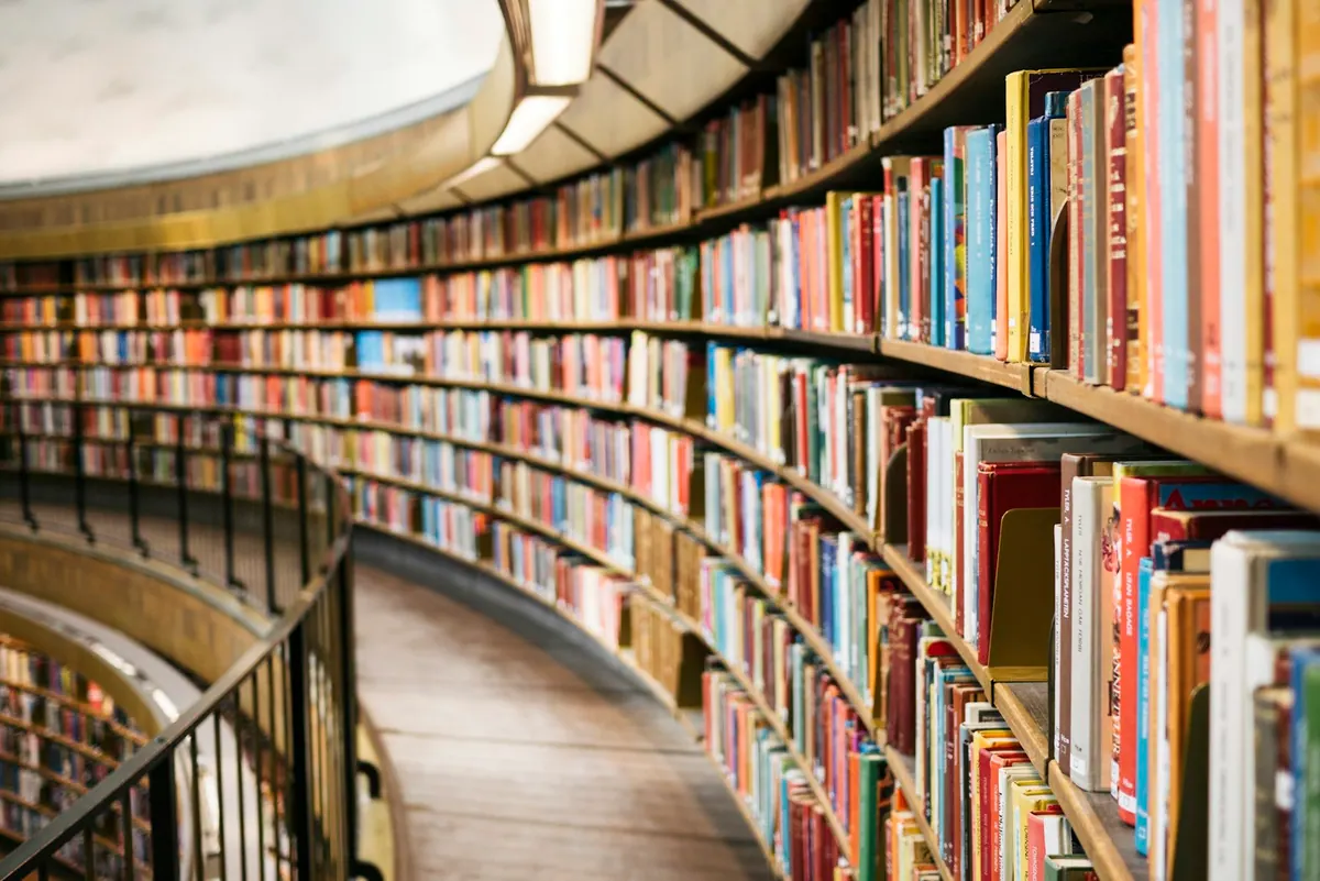 Library shelves of books, curving away into the distance